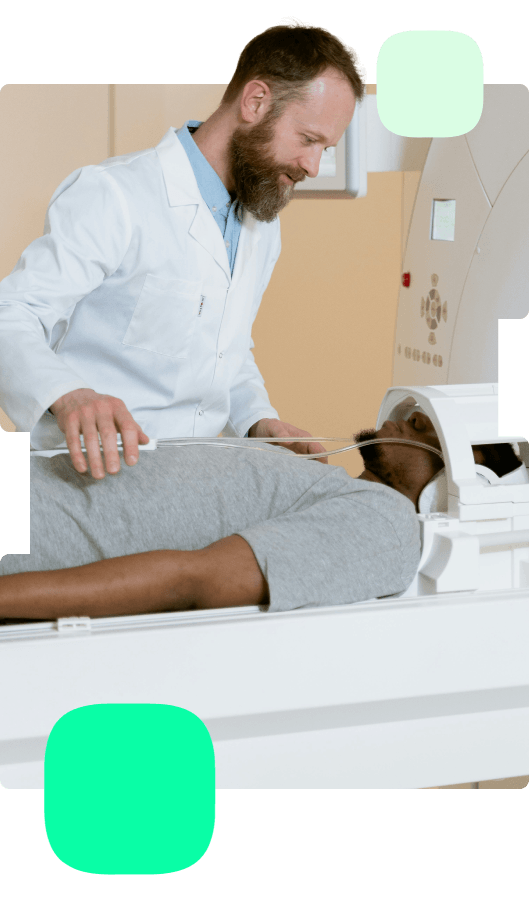 Radiologist preparing a patient for an MRI scan. The patient lies on the scanning bed while the radiologist adjusts equipment inside a modern imaging suite.